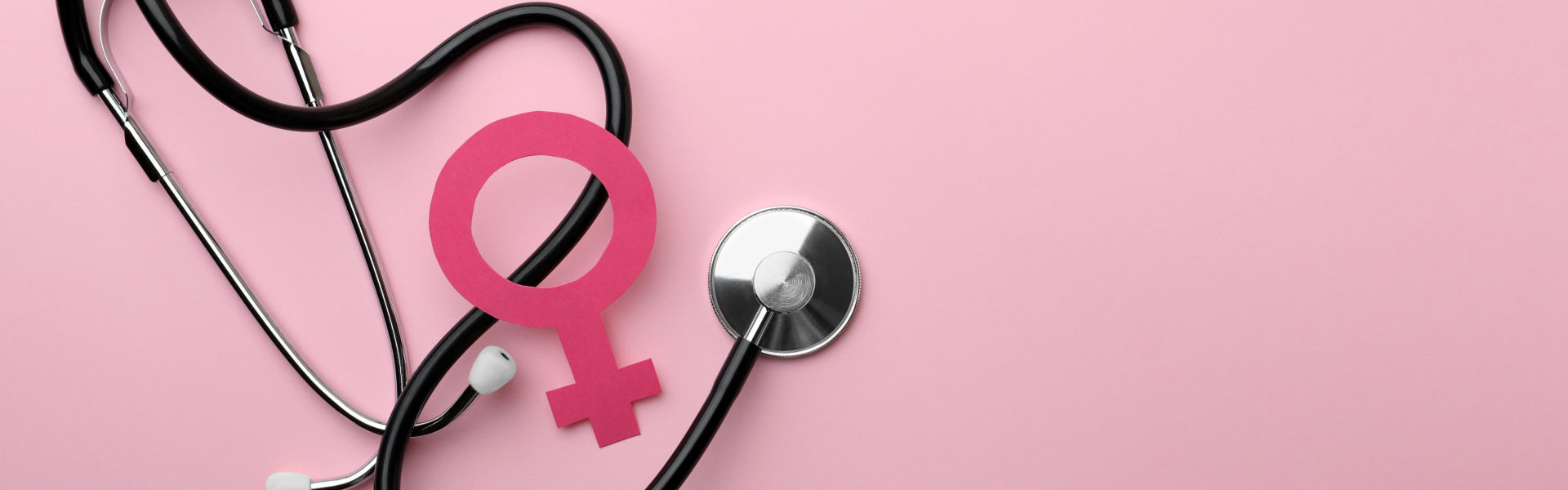 female gender sign and stethoscope on pink background